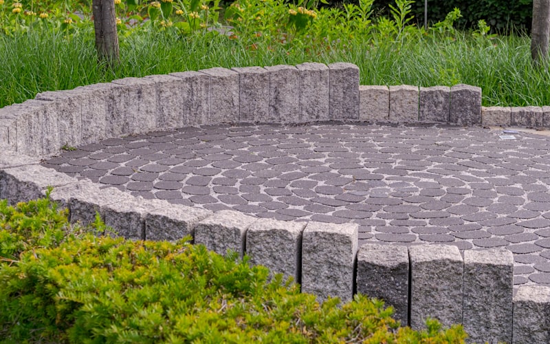 Gepflasterte Fläche mit Steinmauer im Garten